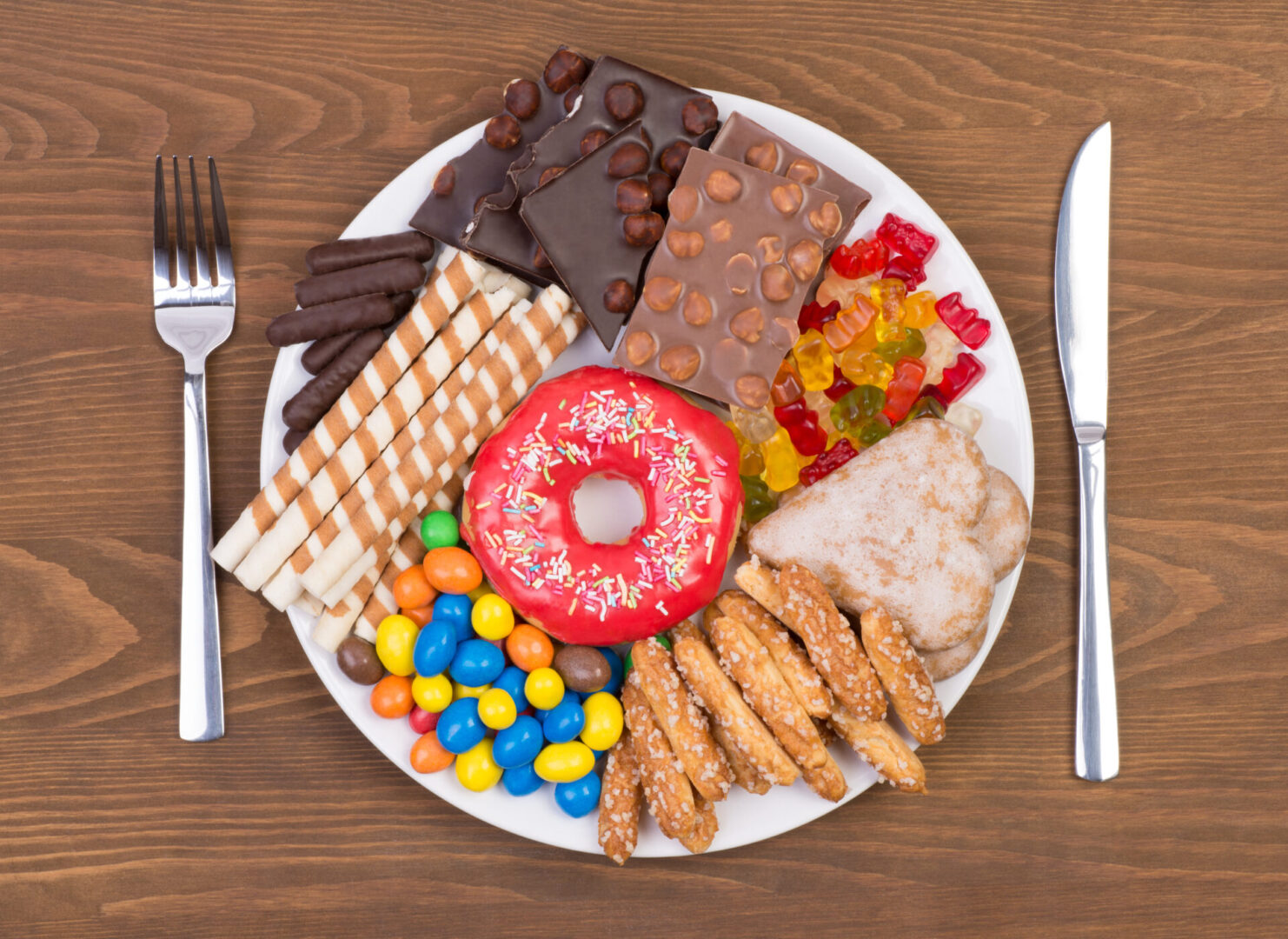 A plate of candies, chocolates, donut, and more