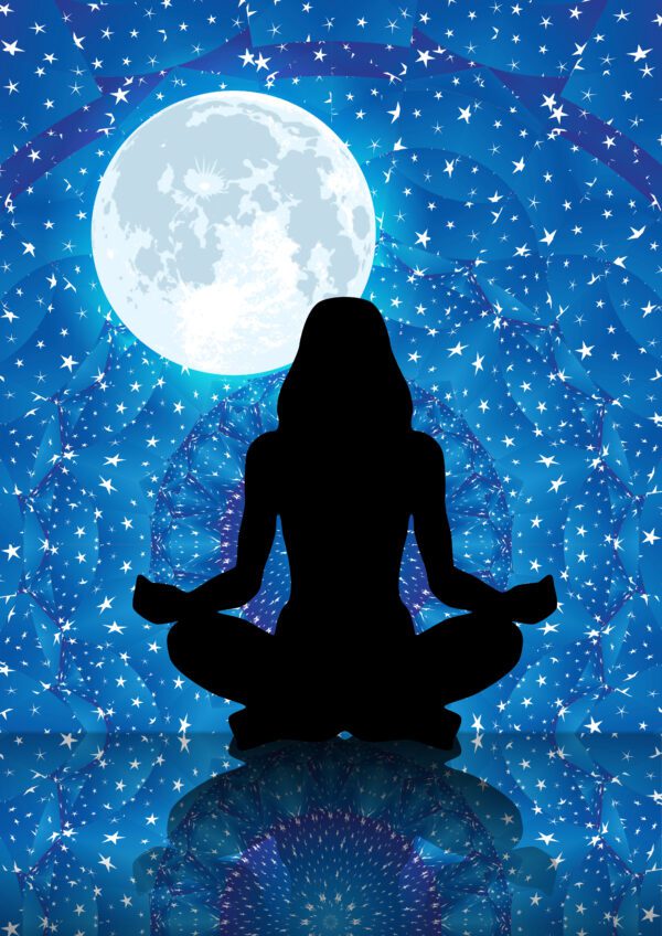 Woman’s silhouette meditating under the moon with mandala background